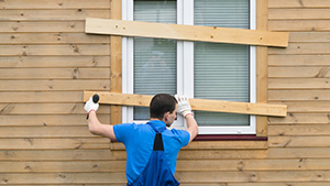 Man preparing his windows for a hurricane.