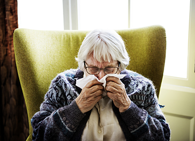 Senior woman sneezing due to mold