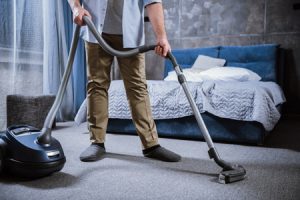 Person using a vacuum to clean carpet mold