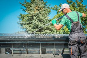 Homeowner cleaning their gutter to fireproof home