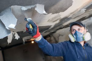 A man working for a fire damage restoration cleans smoke damage