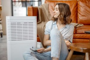 Woman using an air purifier to clean smoke damage