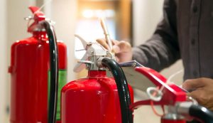employee checking fire extinguishers for fire prevention