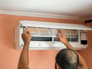 Man checking his AC unit before leaving to prevent mold