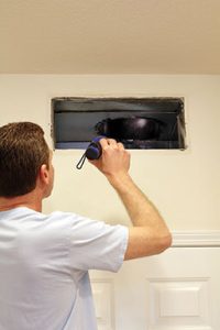 man inspecting air duct for cleaning in the winter