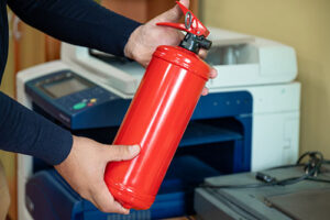 A person holding a fire extinguisher in their hands.